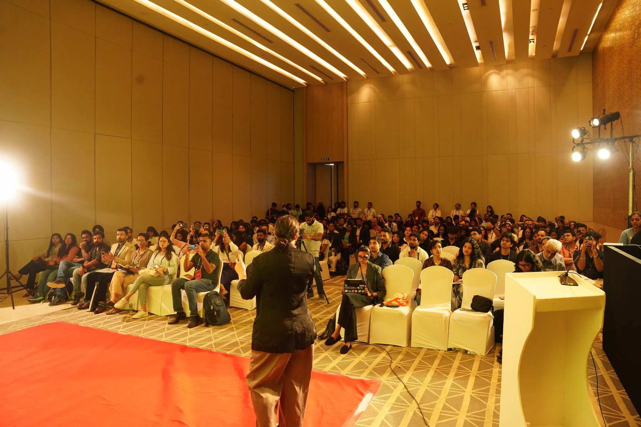 View from the stage of a large conference audience filling the hall at UXINDIA